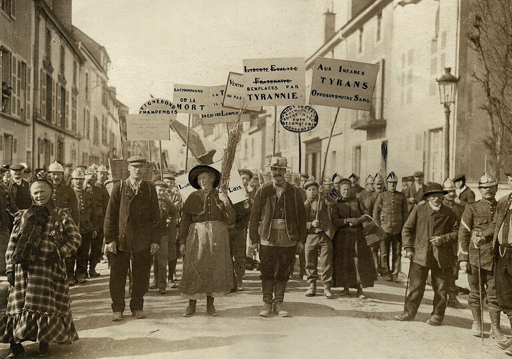 Demonstration of Champagne winegrowers against government measures. Men and women walk through the streets of Bar sur Aube with banners and placards. One of the placards reads 'Champagne ou la Mort'. France, 1911.